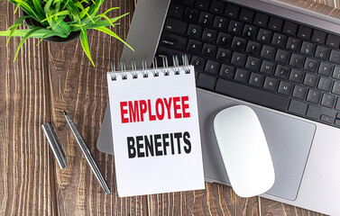 EMPLOYEE BENEFITS text on notebook with laptop, mouse and pen