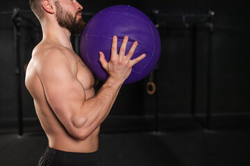Close up of man holding dumbbell in front his bare chest. Routine workout for physical and mental health.