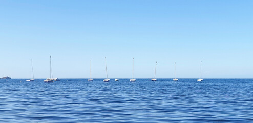 Seascape with sailboats standing in a row. Panorama.