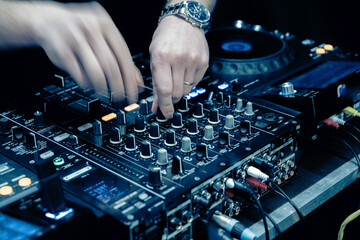 close up of DJ hands on dj console mixer