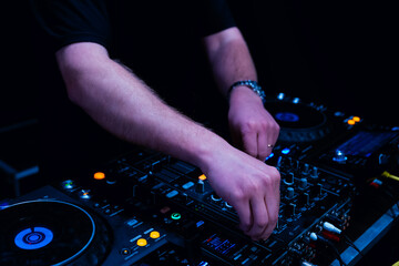 close up of DJ hands on dj console mixer
