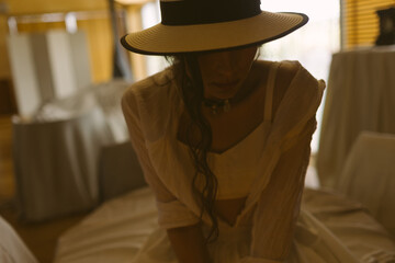 Elegant fashionable woman wearing summer white dress, straw hat, posing in stylish boho interior. - 791548179