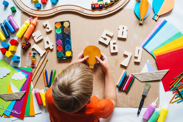 Child drawing and making crafts in school or daycare. - 791548760