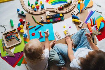 Children drawing and making crafts in kindergarten or daycare.