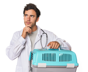 Young Hispanic man as vet with cage looking sideways with doubtful and skeptical expression.