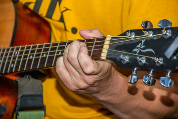 The guitarist's hand presses a chord on the guitar	
