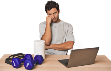 Hispanic trainer planning workout who feels sad and pensive, looking at copy space.