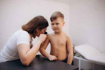 Close-up Of Doctor Examining Skin Of Child Patient With Dermatoscope
