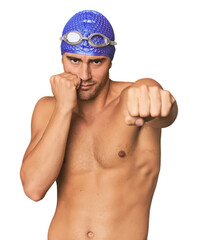 Young Hispanic man with swim gear throwing a punch, anger, fighting due to an argument, boxing.