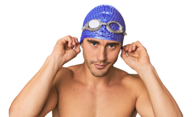Close-up of Hispanic male swimmer with goggles, winner's attitude