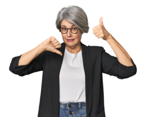 Caucasian mid-age female in business suit showing thumbs up and thumbs down, difficult choose concept