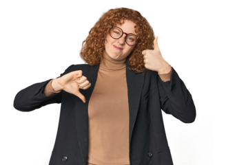 Young Caucasian redhead in business attire showing thumbs up and thumbs down, difficult choose concept