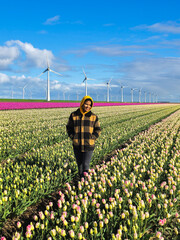 A women is standing amidst a vibrant field of colorful tulips, surrounded by the beauty of nature in full bloom during spring in the Netherlands