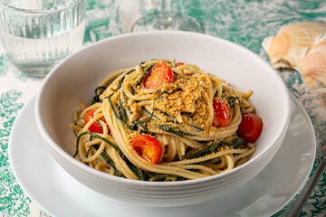 Italian pasta. Spaghetti with agretti, or salsola soda, tomatoes, bread crumbs, pinoli pine nuts in...