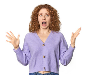 Young Caucasian redhead woman celebrating a victory or success, he is surprised and shocked.