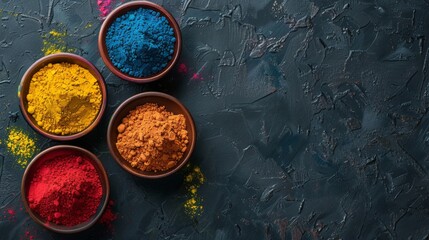 Three bowls of colored powder on a dark surface