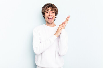 Young caucasian man isolated on blue background feeling energetic and comfortable, rubbing hands confident.
