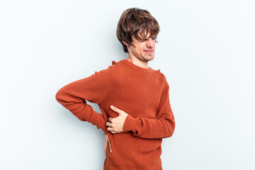 Young caucasian man isolated on blue background suffering a back pain.