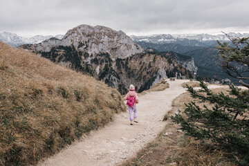 A little girl is hiking alone on the path to mountain top