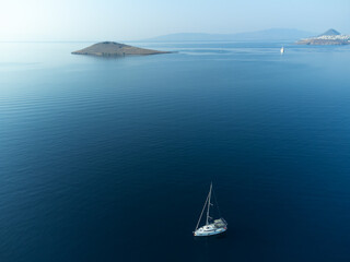 One yacht with a white sail in the open sea, view from a drone. Beautiful luxury yacht with sails...