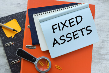 Fixed Asset desktop orange folder calculator. text on a notebook