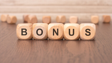 the text 'bonus' is written on wooden cubes on a brown background