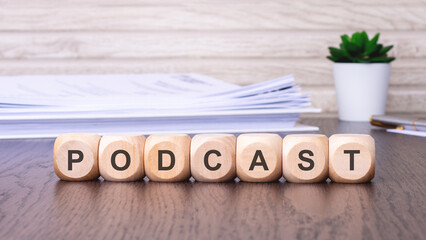 wooden cubes with text PODCAST on brown background