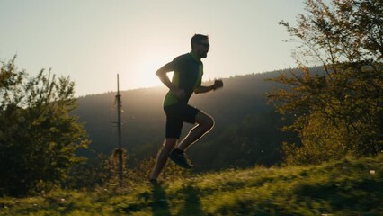 Healthy sportive Caucasian running man male sporty guy athlete sportsman runner exercising run jogging check clock timer sport lifestyle outdoors enjoying fresh air sunny sunbeam mountain hill nature