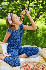 Young Girl With Broken Arm Enjoying Pizza in Sunlit Garden