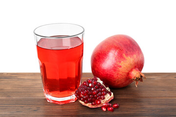 Refreshing pomegranate juice in glass, leaves and seeds on wooden table against white background