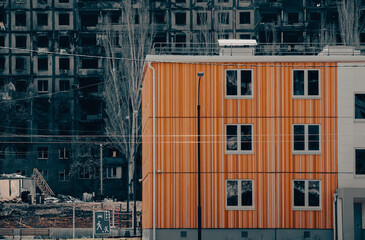 new houses against the backdrop of burnt and destroyed houses in Ukraine