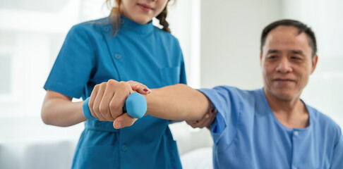 A sick caregiver or young nurse is helping a patient who is rehabilitating with physical therapy at...