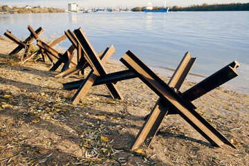 Rusty anti tank hedgehoges on bank of Danube river. Metallic military obstacles constructions...