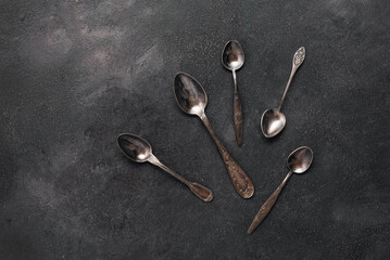 Vintage spoons on a dark grunge background. Top view, flat lay.