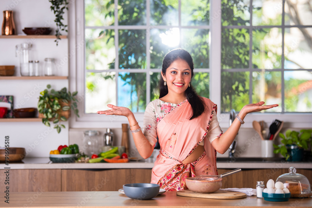 Wall mural portrait of happy indian asian young woman wears saree while working in kitchen - Wall murals