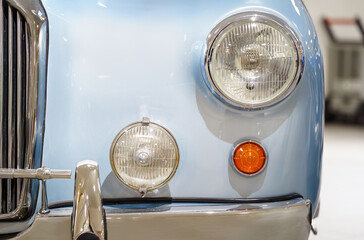 Front view of a vintage light blue car headlights. Classic car. 