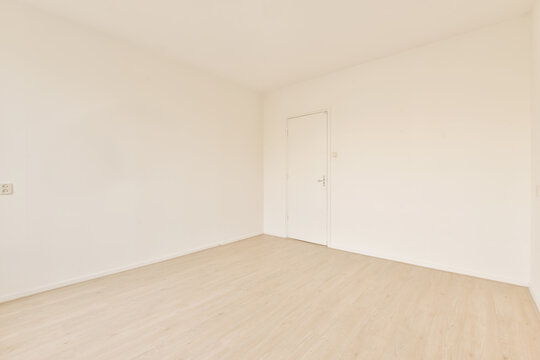 Empty room with wooden floor and white door