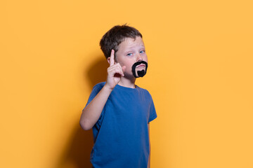 Young boy playing dress up with fake mustache