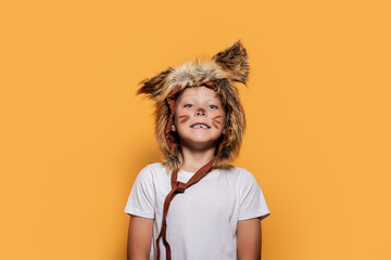 Playful child in animal costume against yellow background