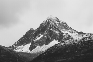 Fototapeta na wymiar A black and white image of a mountain peak, accentuating its stark beauty.