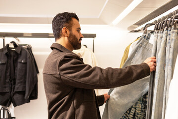 Man selecting jeans at a clothing store