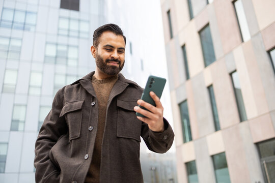 Urban man using smartphone on city street
