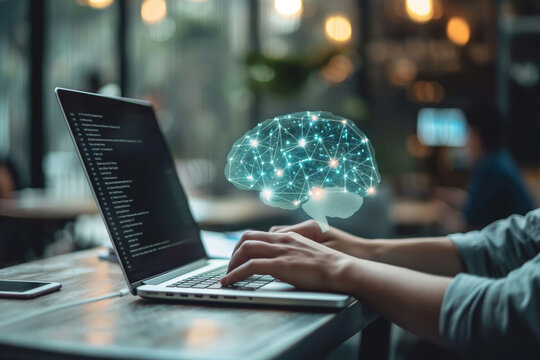 Person works on a laptop with a digital brain hologram, illustrating cognitive processes