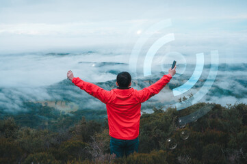 Digital technology, internet network connection digital marketing IoT internet of things. a man holding smartphone standing on top of the mountain with tech icon