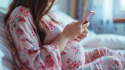 Pregnant Woman Sitting on Bed Looking at Phone