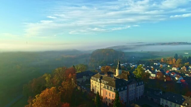 Aerial View of Castle and Village in Scenic Landscape of Germany on Sunny Misty Autumn Morning, Drone Shot