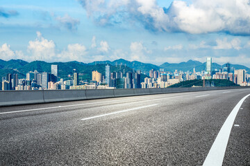 Asphalt highway road and city skyline with green mountain natural background