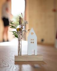 Kleines Symbolhaus mit Blumen als Geschenk