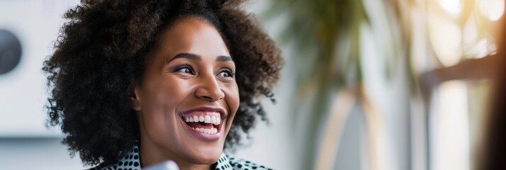 Joyful African American woman with curly hair smiling brightly in a well-lit indoor environment