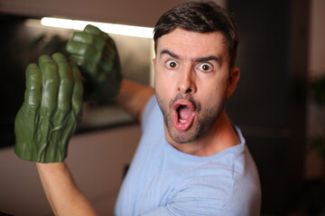 Man wearing large green gloves